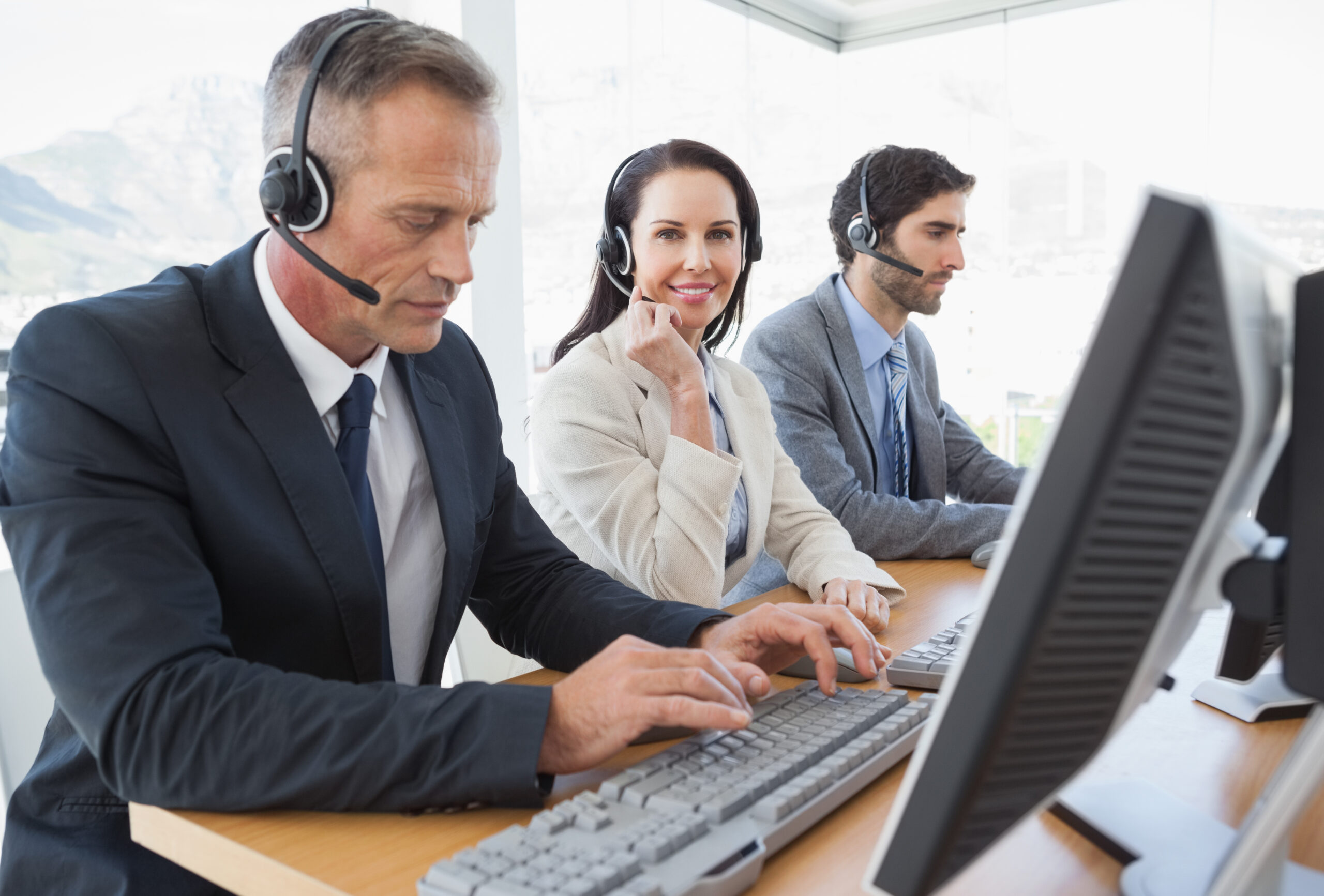 Smiling businesswoman working with teammates in the call center